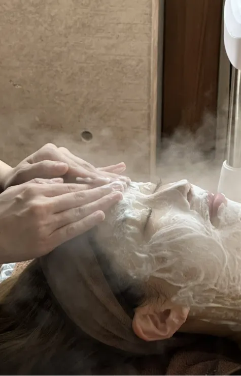 フェイシャルスチームを受ける女性